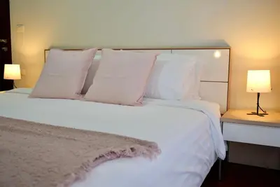 a bedroom with a white bed with pillows and two lamps at Baan Sukhumvit14 in Bangkok