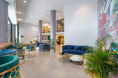 a lobby with a blue couch and some plants at Chill Inn Bangkok in Bang Kapi