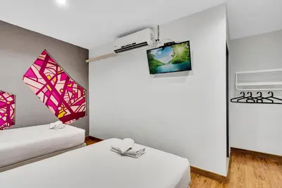 a room with two beds and a tv at Chill Inn Bangkok in Bang Kapi