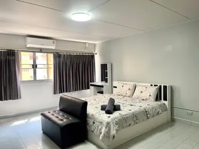 a bedroom with a bed and a black chair at Impact Arena C3 Milo in Nonthaburi