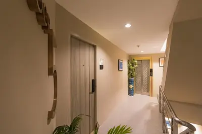 a hallway with a staircase with a door and plants at Heaven Boutique Hotel in Bangkok