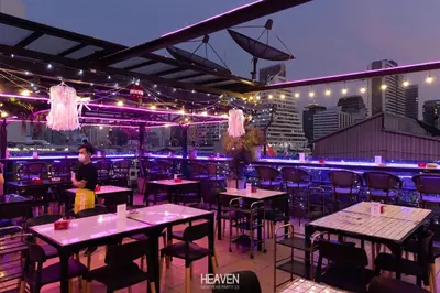 a restaurant with tables and chairs and lights at Heaven Boutique Hotel in Bangkok