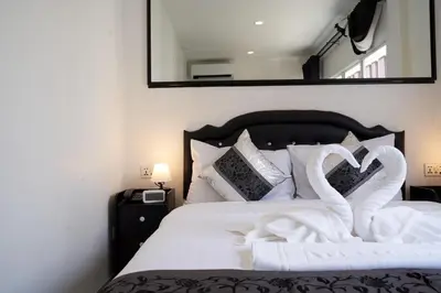 a bed with two swans made to look like hearts at Thonglor Suites Hotel in Bangkok
