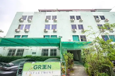 a building with a green sign in front of it at Green Apartment Kaset in Bangkok