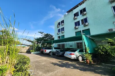 a group of cars parked in front of a building at Green Apartment Kaset in Bangkok