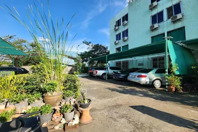 a row of potted plants in front of a building at Green Apartment Kaset in Bangkok
