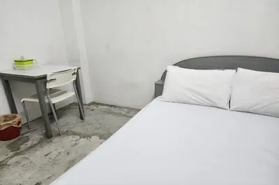 a bedroom with a white bed and a desk at Green Apartment Kaset in Bangkok
