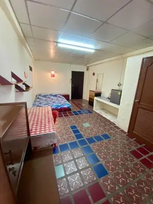 a room with two beds and a floor with colorful tiles at Ratanawong Place 407 in Bangkok