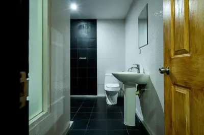 a bathroom with a toilet and a sink and a door at XX GO INN Sukhumvit 20 Bts Asoke-Phrom Phong in Bangkok