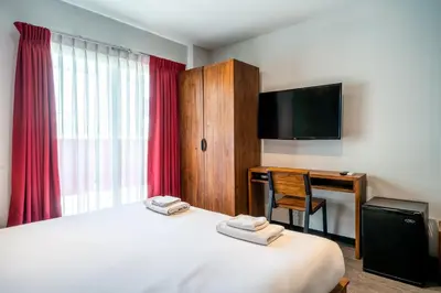 a hotel room with a bed and a desk and a television at XX GO INN Sukhumvit 20 Bts Asoke-Phrom Phong in Bangkok