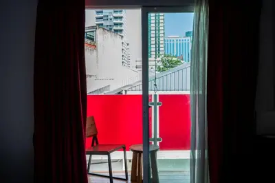 a view of a red wall from a window at XX GO INN Sukhumvit 20 Bts Asoke-Phrom Phong in Bangkok