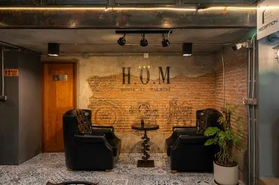 a room with two chairs and a brick wall at House of Machine Boutique Hotel in Bangkok