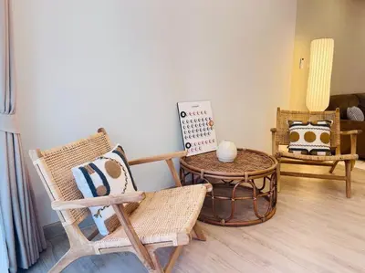 a living room with chairs and a table with a sign at BKK Villa/Huaikwang China Twon in Bangkok