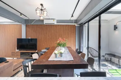 a dining room with a table with flowers on it at S21 Mellow Phromphong in Bangkok