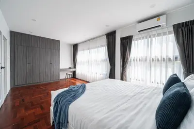 a bedroom with a large white bed with windows at S21 Mellow Phromphong in Bangkok