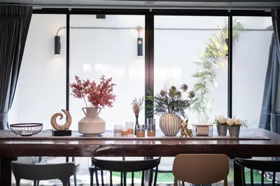 a dining room table with chairs and vases on it at S21 Mellow Phromphong in Bangkok