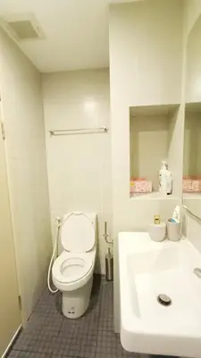 a white bathroom with a toilet and a sink at Elio Del Ray in Bangkok