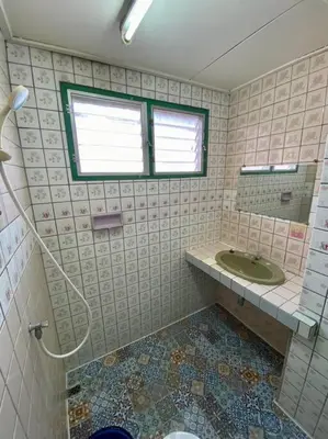 a tiled bathroom with a sink and a mirror at Ratanawong Place 206 in Bangkok