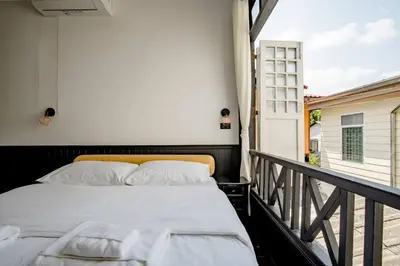 a bedroom with a bed on a balcony at Haheng House in Bangkok