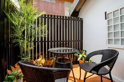 a patio with chairs and a table and a fence at Haheng House in Bangkok
