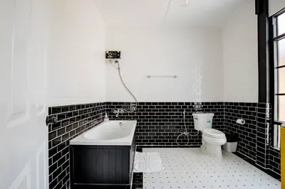 a black and white bathroom with a tub and a toilet at Haheng House in Bangkok