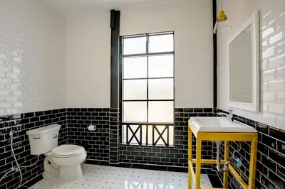 a bathroom with a white toilet and a sink at Haheng House in Bangkok