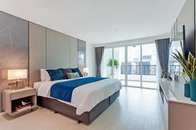 a bedroom with a large bed and a balcony at GM Residence in Bangkok