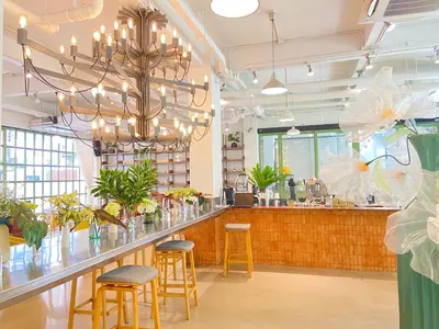a restaurant with a bar with stools and a chandelier at Beat Hotel Bangkok in Bangkok