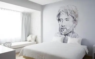 a bedroom with a drawing of a man on the wall at Beat Hotel Bangkok in Bangkok