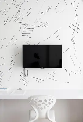 a living room with a tv and a white chair at Beat Hotel Bangkok in Bangkok