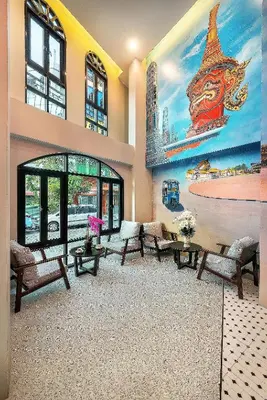 a lobby with a large mural on the wall at Phra Nakhon Poshtel in Bangkok