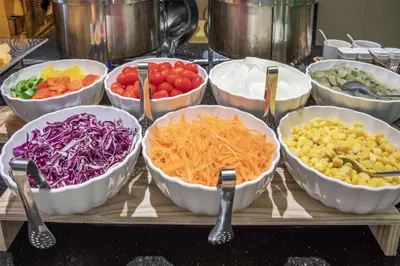 a table topped with bowls of different types of vegetables at Best Western Ratchada Hotel in Bangkok