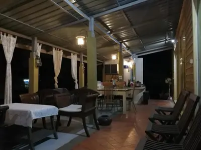 a dining room and living room with a table and chairs at นอนในสวน รีสอร์ท in Bangkok