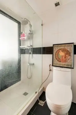 a bathroom with a shower and a toilet and a glass shower at SelfCheckIn Omni Tower Sukhumvit4 NaNa Asoke BTS MRT Hispeed WiFi Pool&Gym in Bangkok