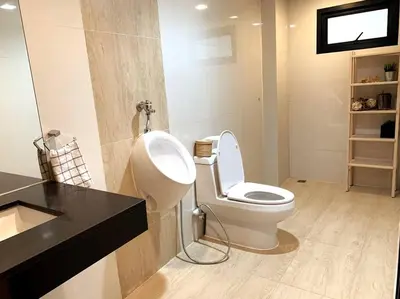 a bathroom with a white toilet and a sink at Joyful Modern Home with Foods and MRT Rama 9 Nearby in Bangkok