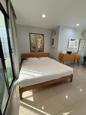 a bedroom with a large bed and a table at Joyful Modern Home with Foods and MRT Rama 9 Nearby in Bangkok