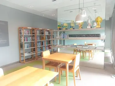 a library with wooden tables and chairs and bookshelves at Rooms bangkok nearby Onnut bts in Amphoe Phra Khanong