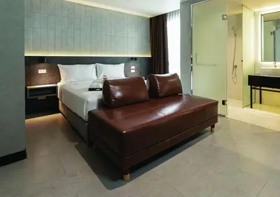 a hotel room with a bed and a leather couch at EX2 Hotel in Ban Bang Khen (1)
