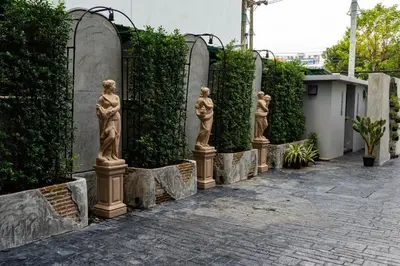 a row of statues in front of a fence at J PLACE HOTEL in Bangkok
