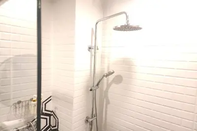 a shower with a glass door in a bathroom at J PLACE HOTEL in Bangkok