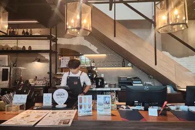 a person standing in a kitchen preparing food at J PLACE HOTEL in Bangkok