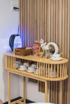 a wooden shelf with cups and dishes on it at Bangkok Cozy Garden Pool Villa Sukhumvit in Amphoe Phra Khanong