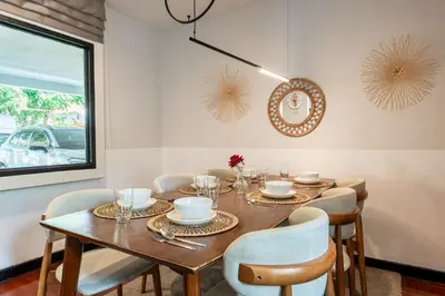 a dining room with a wooden table and chairs at Bangkok Cozy Garden Pool Villa Sukhumvit in Amphoe Phra Khanong
