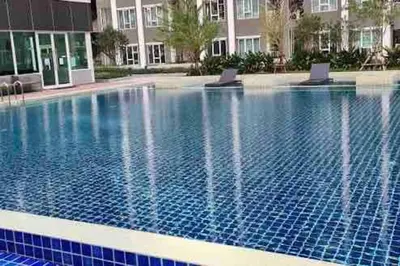 a swimming pool with two chairs in a building at Minimal Cozy Room near Chatuchak Weekend Market #1 in Bangkok