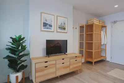 a living room with a television on a wooden dresser at Minimal Cozy Room near Chatuchak Weekend Market #1 in Bangkok