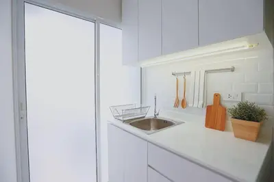 a white kitchen with a sink and a counter at Minimal Cozy Room near Chatuchak Weekend Market #2 in Bangkok