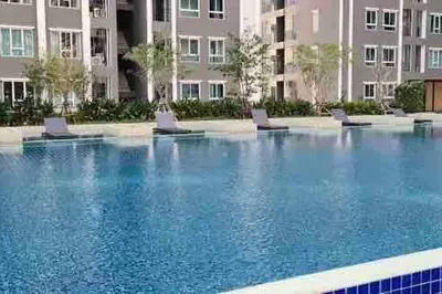 a large swimming pool with chairs in front of a building at Minimal Cozy Room near Chatuchak Weekend Market #2 in Bangkok