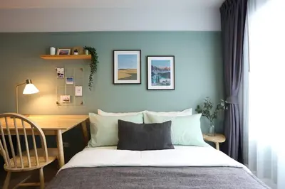a bedroom with a bed and a table and a desk at WoodGreen Room near Chatuchak Weekend Market in Bangkok
