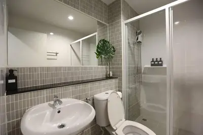 a bathroom with a toilet and a sink and a shower at WoodGreen Room near Chatuchak Weekend Market in Bangkok