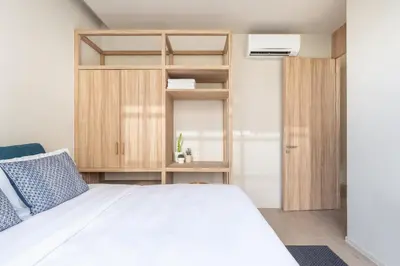 a bedroom with a white bed and wooden cabinets at Silom Nara in Bangkok